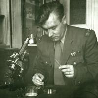 celník v dobové uniformě u mikroskopu